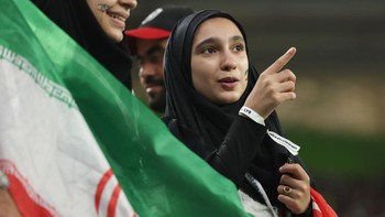 Suporter perempuan asal Iran sedang berbincang dengan rekannya. Foto: Getty Images