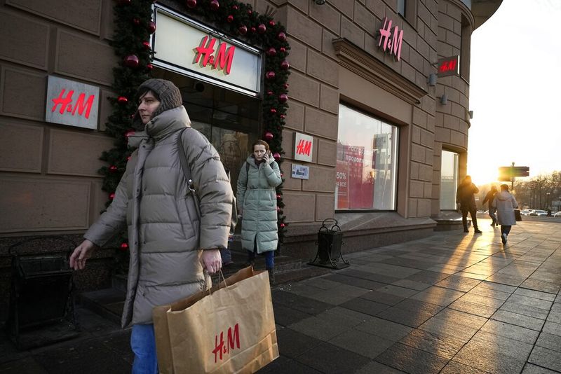 People enter H&M's flagship Moscow store for the last time before the world's No.2 fashion retailer closes all its stores in Russia for good, Moscow, Russia, Wednesday, Nov. 30, 2022. H&M shut its stores soon after Russia sent tens of thousands of troops into Ukraine, before reopening to snaking queues of people in August to sell surplus inventory. The crowds were not so large on Wednesday, but those who made the effort were rewarded with fully stocked shelves and 50% off everything. (AP Photo/Alexander Zemlianichenko)