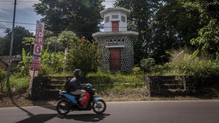 Pengendara roda dua melintas di depan menara air peninggalan Kolonial Belanda di Warunggunung, Lebak, Banten, Senin (28/11/2022). Menara air yang dibangun oleh pemerintah Kolonial Belanda pada tahun 1931 yang sudah tidak difungsikan tersebut dulunya digunakan untuk menyalurkan air dari Kabupaten Pandeglang menuju Kabupaten Lebak. ANTARA FOTO/Muhammad Bagus Khoirunas/hp.