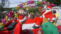 Peserta karnaval mengenakan pakaian Santa Claus, diarak menggunakan mobil bak di sepanjang Jalan Ahmad Yani, Kota Sorong, Papua Barat, Kamis (1/12/2022). Pemerintah Kota Sorong mencanangkan awal bulan Desember sebagai bulan Natal.