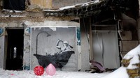 Mural itu menggambarkan sosok pria berjenggot putih dan panjang, serta kepala plontos sedang mandi di dalam bath-up. Foto: Getty Images/Jeff J Mitchell