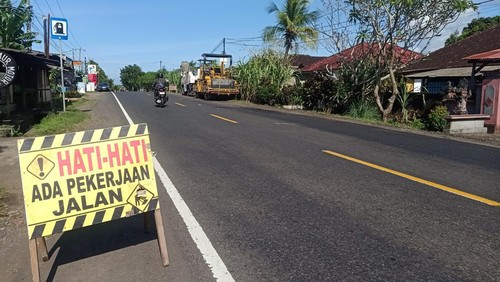 Pekerja saat melakukan penambalan jalan Nasional Denpasar-Gilimanuk, tepatnya di Desa Banyubiru, Kecamatan Negara, Kabupaten Jembrana, Kamis (01/12/2022).