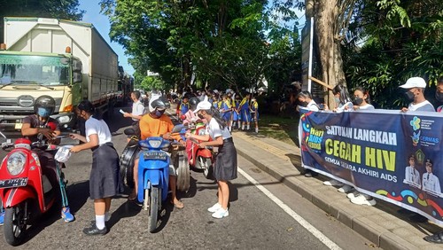 Puluhan siswa di Jembrana membagikan brosur dan bunga dalam rangka Hari AIDS Sedunia di Traffic Light Makam Pahlawan, Kelurahan Pendem, Kecamatan Jembrana, Kabupaten Jembrana, Bali, Kamis (1/12/2022).