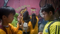 Tampak sang guru turut membantu serta mengajarkan mereka dalam menggambar mural tersebut. 
