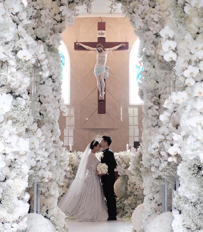 Dalam foto-foto yang sibagikan terlihat gereja tempat pernikahan Sisca dan Jess dipenuhi dengan begitu banyak bunga berwarna putih. Mulai dari altar hingga lorong tempat pengantin berjalan tampak begitu cantik didekorasi dengan bunga anggrek putih. Foto: Instagram/@siscakohl