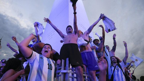 Argentina soccer fans celebrate their teams winning match against Poland at the World Cup, near the Obelisk in Buenos Aires, Argentina, Wednesday, Nov. 30, 2022. (AP Photo/Gustavo Garello)