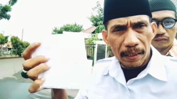 Tatang Jauhari murka dan meminta amplopnya ke ketua-ketua RW di Bedahan, Sawangan, Depok, dikembalikan karena kalah dalam pemilihan LMP