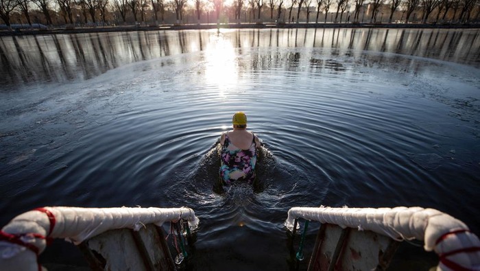 This photo taken on November 30, 2022 shows a winter swimming enthusiast swimming in a partly frozen lake in Shenyang, in northeastern China's Liaoning province. - China OUT (Photo by AFP) / China OUT (Photo by STR/AFP via Getty Images)