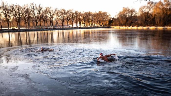 This photo taken on November 30, 2022 shows a winter swimming enthusiast swimming in a partly frozen lake in Shenyang, in northeastern China's Liaoning province. - China OUT (Photo by AFP) / China OUT (Photo by STR/AFP via Getty Images)