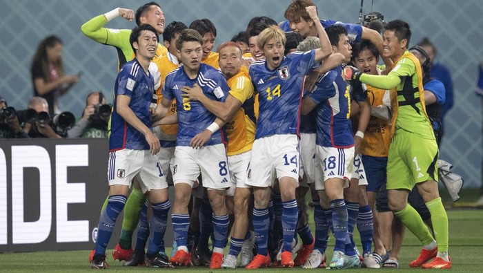DOHA, QATAR - NOVEMBER 23: Ritsu Doan is swamped by his team-mates after scoring Japans first goal during the FIFA World Cup Qatar 2022 Group E match between Germany and Japan at Khalifa International Stadium on November 23, 2022 in Doha, Qatar. (Photo by Sebastian Frej/MB Media/Getty Images)
