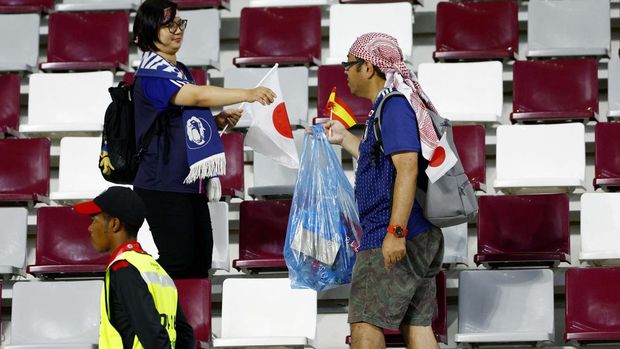 Soccer Football - FIFA World Cup Qatar 2022 - Group E - Japan v Spain - Khalifa International Stadium, Doha, Qatar - December 1, 2022Japan fans pick up litter inside the stadium after the match REUTERS/Susana Vera