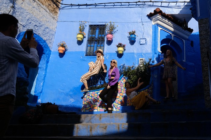 CHEFCHAOUEN, MOROCCO - NOVEMBER 14: Tourists pose for a photograph in the blue city of Chefchaouen, Morocco on November 14, 2018. Chefchaouen also known as Chaouen, is called the 