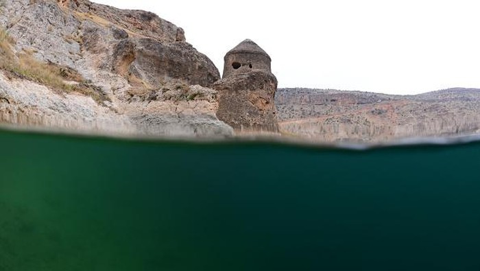 DIYARBAKIR, TURKIYE - NOVEMBER 30: A diver swims through the historical ruins of Ottoman, Byzantine, Roman, Assyrian, and Seljuk origin submerged in water at Dicle Dam Lake in Diyarbakir, Turkiye on November 30, 2022. Underwater cinematographer Tahsin Ceylan and his team dived into the Dicle Dam Lake, which has become the 