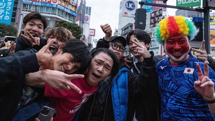 Fans celebrate after Japans victory over Spain in the Qatar 2022 World Cup Group E football match to advance to the last 16, at the Shibuya Crossing area in Tokyo on December 2, 2022. (Photo by Richard A. Brooks / AFP) (Photo by RICHARD A. BROOKS/AFP via Getty Images)
