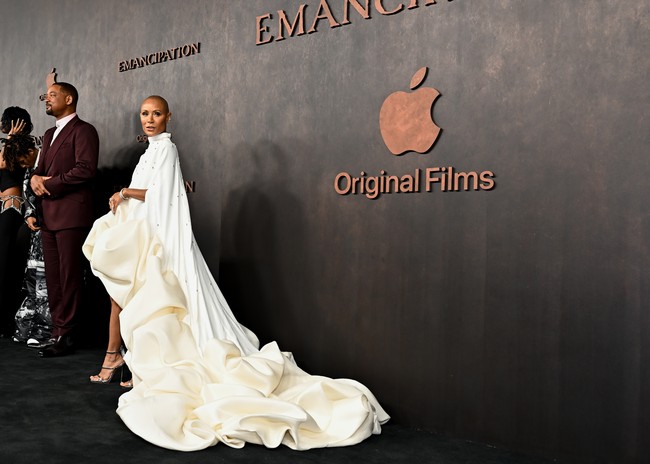 Sementara itu, gaun putih rancangan Stephane Rolland menjadi andalan Jada Pinkett. Gaun bersiluet A tersebut dihiasi detail kristal dan kerutan bervolumen nan dramatis yang memanjang hingga menyapu lantai. (Foto: Variety via Getty Images/Michael Buckner)