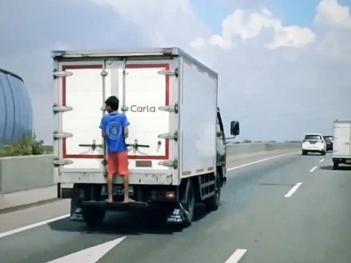 Aksi bocah gelantungan di belakang mobil yang melaju di Tol Priok (dok.tangkapan layar)
