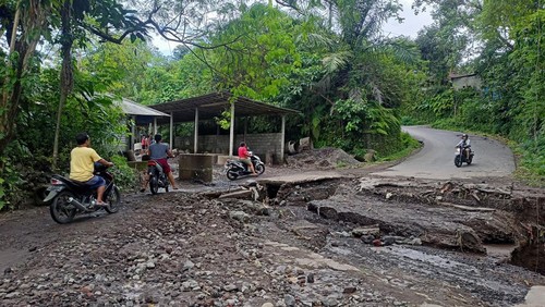 Beberapa masyarakat saat melewati jalan Ababi-Budakeling yang jebol dengan berhati-hati (foto : I Wayan Selamat Juniasa)
