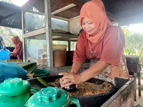 Marni, menggiling bumbu kacang untuk lontong pecal legendaris di Asahan.