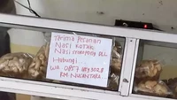 Etalase di warung ini bertuliskan bahwa si penjual menawarkan nasi kotak. Namun, makanan yang dipajang bukannya lauk-pauk melainkan camilan makaroni. Foto: Twitter