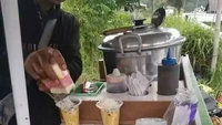 Di lapak jualannya terdapat tulisan bahwa menu yang ditawarkan adalah sosis bakar. Namun, si penjual justru menawarkan jagung susu keju (jasuke). Foto: Twitter