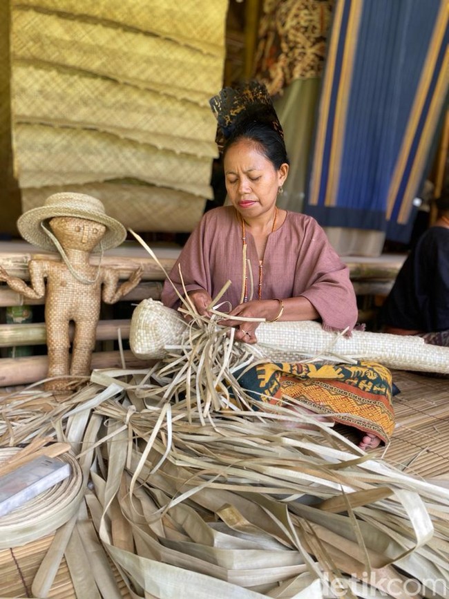 Tatu Analodu, salah satu mama yang diboyong Edo, sedang membuat semacam patung manusia dari daun pandan. Menurut kepercayaan Marapu, agama kuno di Sumba, benda tersebut diyakini dapat menangkal bala penyakit. Selain bangga bisa terlibat di Rumah Sumba, Tatu juga mengaku senang karena untuk pertama kalinya dia bepergian dengan pesawat. (Foto: Daniel Ngantung/detikcom)