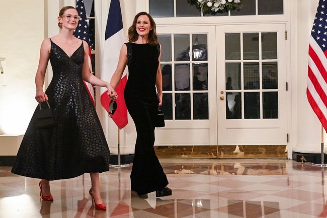 Violet dan Jennifer mengenakan busana hitam. Violet yang kini sudah berusia 17 tahun mengenakan gaun hitam berpotongan leher heart-shaped koleksi Carolina Herrera. Foto: Getty Images/Nathan Howard
