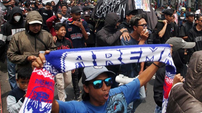 Aksi Aremania Tuntut Penuntasan Tragedi Kanjuruhan Suporter Arema FC (Aremania) menyalakan api suar (flare) saat berunjuk rasa dan memblokir jalan di perempatan jalan Ciliwung, Malang, Jawa Timur, Minggu (4/12/2022). Unjuk rasa dengan memblokir jalan selama dua jam yang dilakukan Aremania di sejumlah titik di Kota Malang tersebut merupakan bentuk protes terhadap aparat penegak hukum atas penanganan kasus Tragedi Kanjuruhan yang dinilai jalan di tempat. ANTARA FOTO/Ari Bowo Sucipto/aww.