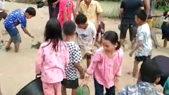 Aksi bocil menangkap ikan di kubangan lumpur jalan yang rusak. (Foto: Istimewa)