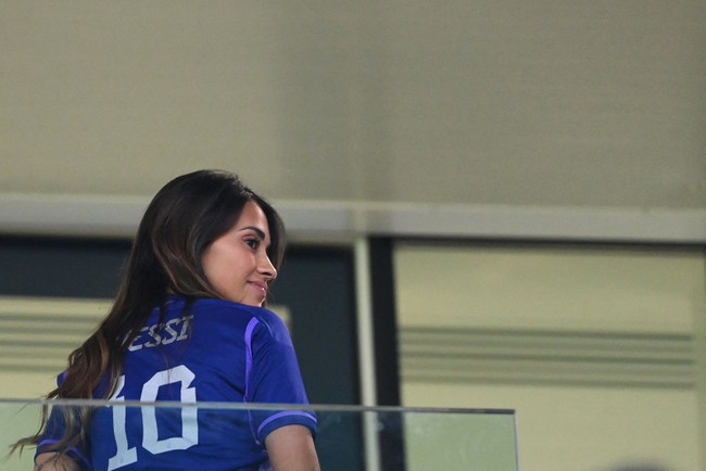 Antonela Roccuzzo tampil dengan jersey ungu Argentina saat menonton suaminya bertanding di Piala Dunia Qatar 2022. Dia mengenakan jersey bernomor punggung 10 yang merupakan milik Lionel Messi. Foto: AFP via Getty Images/ODD ANDERSEN