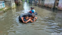 Anak-anak warga Kampung Bojongasih, Desa Dayeuhkolot, Kabupaten Bandung berenang di genangan banjir. Foto: Yuga Hassani/detikJabar