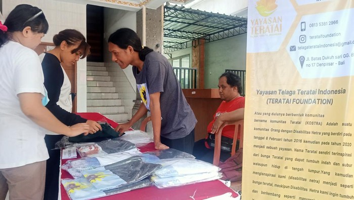 Ketua Yayasan Telaga Teratai Indonesia, Made Jerry Juliawan ketika tengah menawarkan produk kaos karya penyandang disabilitas tunanetra pada Minggu (4/12/2022) di Gedung Graha Nawasena, Jalan Kamboja No 4 Denpasar, Bali. (Ni Made Lastri Karsiani Putri)