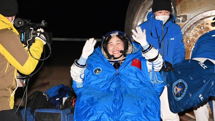 This photo taken on December 4, 2022 shows Chinese astronaut Liu Yang waving as officials assist her from the capsule of the Shenzhou-14 spacecraft after landing in Chinas Inner Mongolia. - China OUT (Photo by CNS / AFP) / China OUT (Photo by -/CNS/AFP via Getty Images)