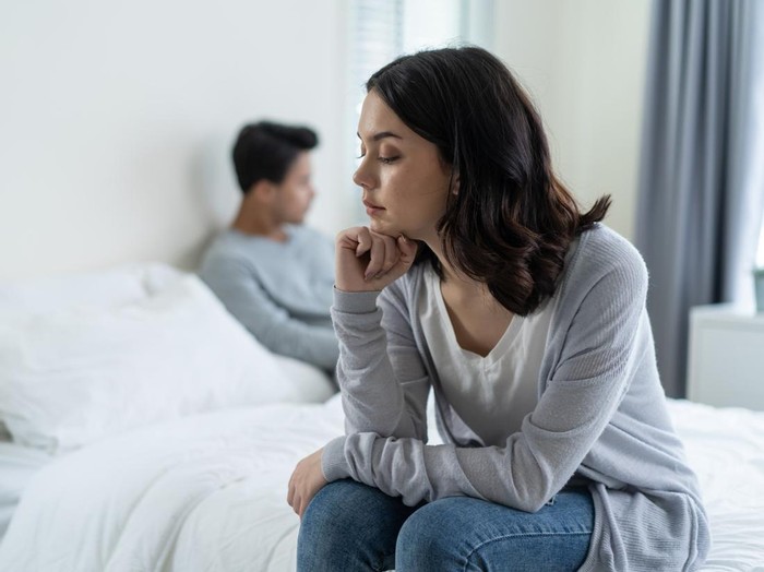Asian young girl feel angry boyfriend having conflict domestic problem. New marriage man and woman feel heartbroken for quarrel conflict while sit on bed in bedroom. Family problem-separation concept.