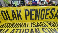 Dalam aksinya massa membawa spanduk tuntutan hingga bendera kuning. 