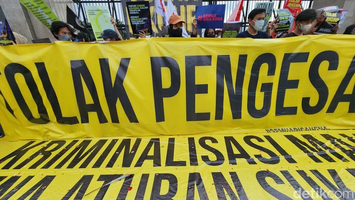 Aksi Menolak Pengesahan RUU KUHP di DPR Massa dari berbagai elemen aktivis menggelar unjuk rasa di depan Gedung DPR/MPR RI, di Jl Gatot Subroto, Jakarta, Senin (5/12/2022). Mereka mendesak DPR untuk mengurungkan pengesahan RUU KUHP pada sidang paripurna. Dalam aksinya, mereka menggelar spanduk besar, poster dan bendera kuning bertuliskan berbagai tuntutan. Hingga pukul 14.45 WIB, aksi masih berlangsung dengan tertib dan aman.