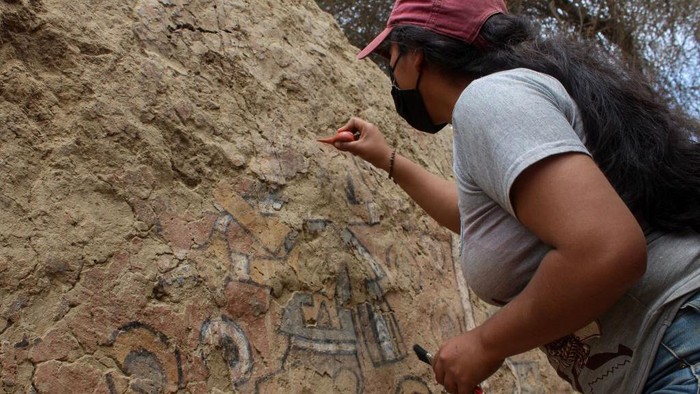 An undated picture shows an archeologist uncovering a pre-Hispanic wall painting with mythological scenes uncovered near the Lambayeque town of Illimo in northern Peru, after decades it was considered lost by archaeologists. - A team of archaeologists led by Swiss Sam Ghavanmi found a 1,000-year-old mural, known as the 