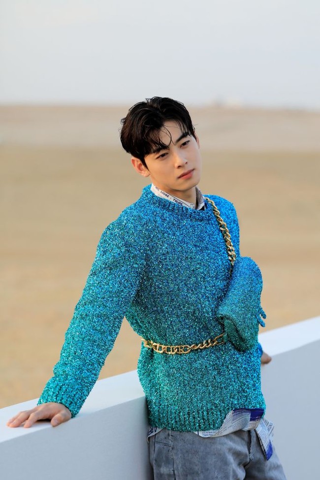 Bak pangeran, Cha Eun Woo tampil memesona saat berpose di belakang pemandangan Piramida Agung Giza. Personel grup ASTRO itu memakai kemeja putih dengan newspaper print di balik sweater Dior Men Fall 2023 warna tosca yang serasi dengan tas yang dikenakannya. Foto: Getty Images