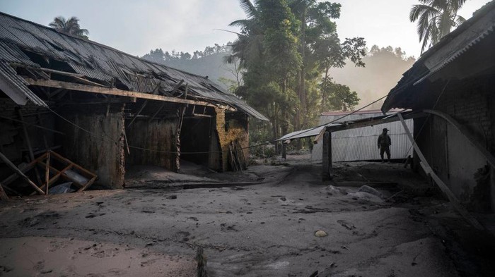 Dusun Kajar Kuning Luluh Lantak Tertimbun Abu Vulkanik Semeru A man checks a house following a volcanic eruption by Mount Semeru at Kajar Kuning village in Lumajang on December 5, 2022. - Indonesia's Mount Semeru erupted on December 4 spewing hot ash clouds a mile high and rivers of lava down its side while sparking the evacuation of nearly 2,000 people exactly one year after its last major eruption killed dozens. (Photo by JUNI KRISWANTO / AFP) (Photo by JUNI KRISWANTO/AFP via Getty Images)
