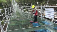 Pekerja sedang membersihkan lantai kaca jembatan kaca Bromo (Foto: M Rofiq)