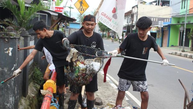 Kelompok anak muda Kalangsari Pride sedang beraksi membersihkan sampah di lingkungannya.