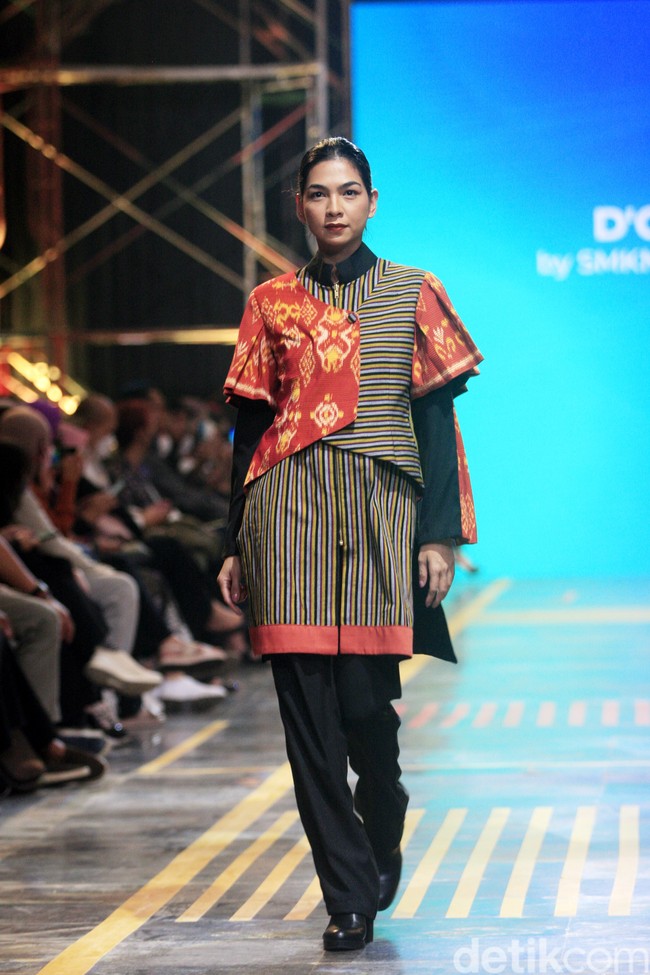 Siswa SMK 1 Kalitengah Lamongan menampilkan koleksi busana yang terinspirasi dari gapura Paduraksa Lamongan di malam hari dengan pesona keindahan warna warninya. Fashion show digelar di Spotlight Indonesia 2023.  Foto: Mohammad Abduh/Wolipop.  