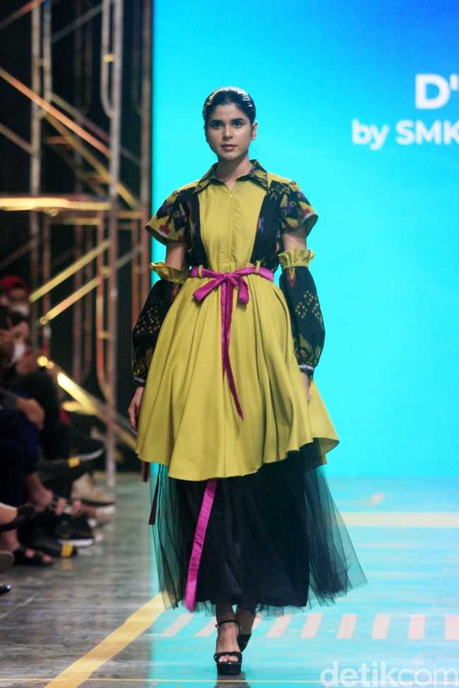 Siswa SMK 1 Kalitengah Lamongan menampilkan koleksi busana yang terinspirasi dari gapura Paduraksa Lamongan di malam hari dengan pesona keindahan warna warninya. Fashion show digelar di Spotlight Indonesia 2023. Foto: Mohammad Abduh/Wolipop.  
