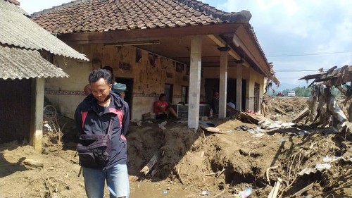 Warga saat melaksanakan pembersihan rumah dari lumpur pasca diterjang banjir bandang pada 16 Oktober 2022.