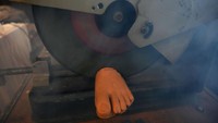 Penampakan kaki palsu yang sedang dipotong menggunakan mesin.  