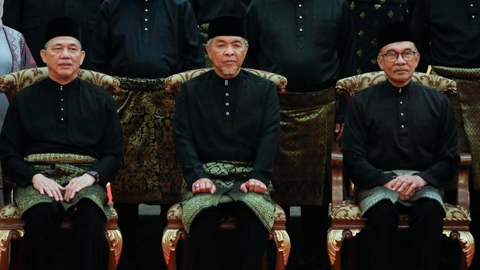 Malaysias Prime Minister Anwar Ibrahim (R) poses with Deputy Prime Ministers Ahmad Zahid Hamidi (C) and Fadillah Yusof (L) after the swearing-in ceremony of the newly appointed cabinet ministers at the National Palace in Kuala Lumpur, on December 3, 2022. (Photo by HASNOOR HUSSAIN / POOL / AFP)