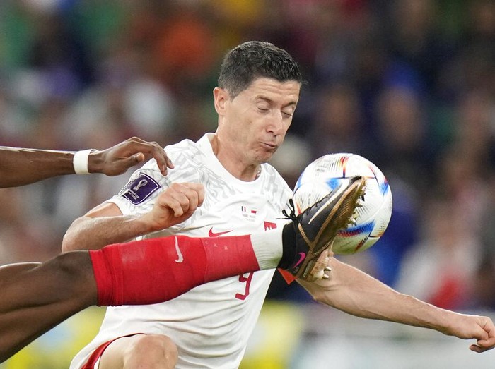 France's Aurelien Tchouameni, left, fights for the ball with Poland's Robert Lewandowski during the World Cup round of 16 soccer match between France and Poland, at the Al Thumama Stadium in Doha, Qatar, Sunday, Dec. 4, 2022. (AP Photo/Moises Castillo)
