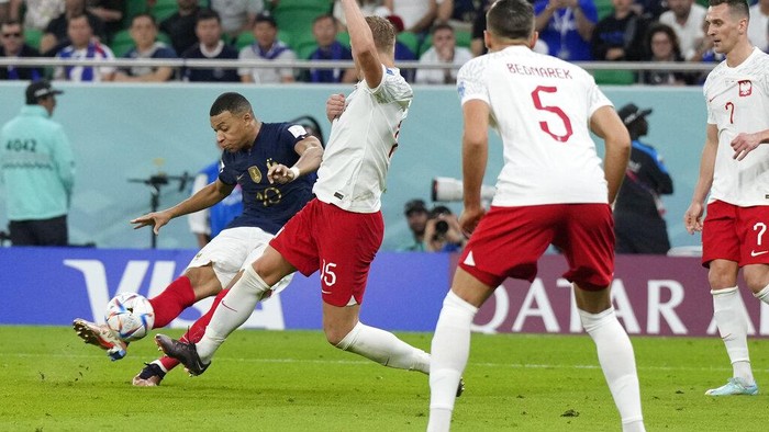 Frances Kylian Mbappe, left, scores his sides third goal during the World Cup round of 16 soccer match between France and Poland, at the Al Thumama Stadium in Doha, Qatar, Sunday, Dec. 4, 2022. (AP Photo/Ricardo Mazalan)