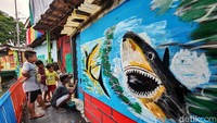 Sejumlah anak-anak ikut melihat proses pengecatan yang dilakukan oleh salah satu warga.