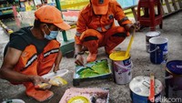 Tampak warga dan petugas kelurahan mempersiapkan proses pengecatan yang akan mempercantik kawasan lingkungan tersebut.