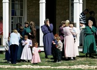 Adult members of The Fundamentalist Church of Jesus Christ of Latter-day Saints gather as children play with bottles of bubble water on the grounds of their temporary housing at Fort Concho National Historic Landmark in San Angelo, Texas, Apr. 7, 2008. (AP Photo/Tony Gutierrez)